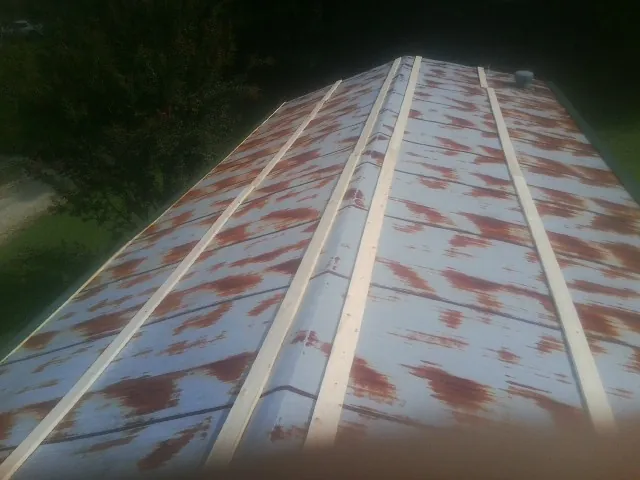 Rusted metal roof panels with new wood purlins before replacement — Storm Damage Roof Repair in Hill City by Roofing Brothers